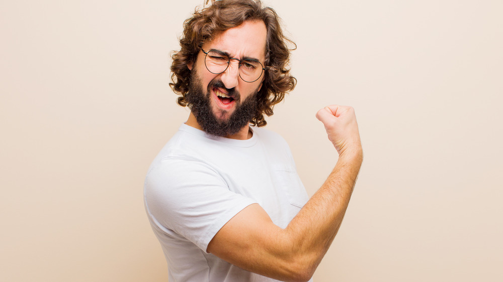 Guy with a beard flexing his biceps