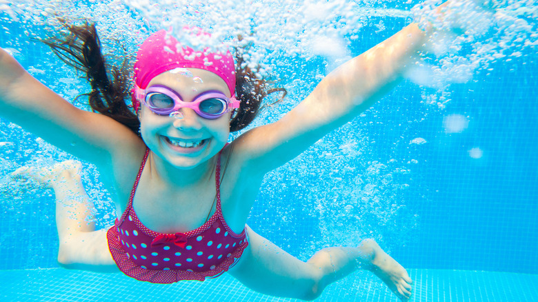 Girl swimming underwater and smiling