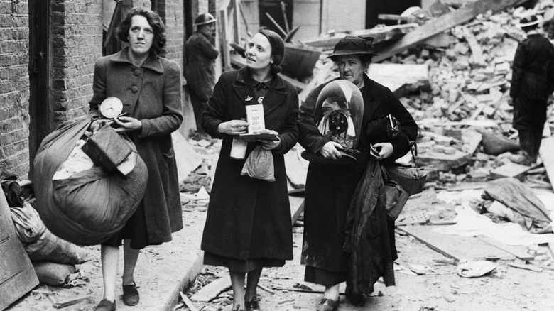 british women walk through a part of london damaged by german bombing