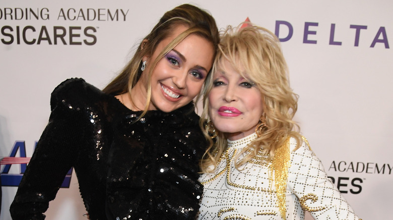 Miley Cyrus and Dolly Parton posing for a photo together