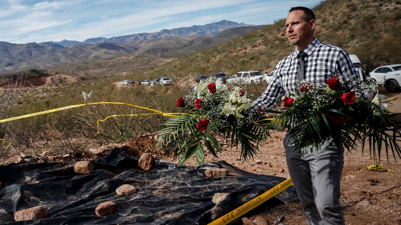 Man holding flowers at crime scene