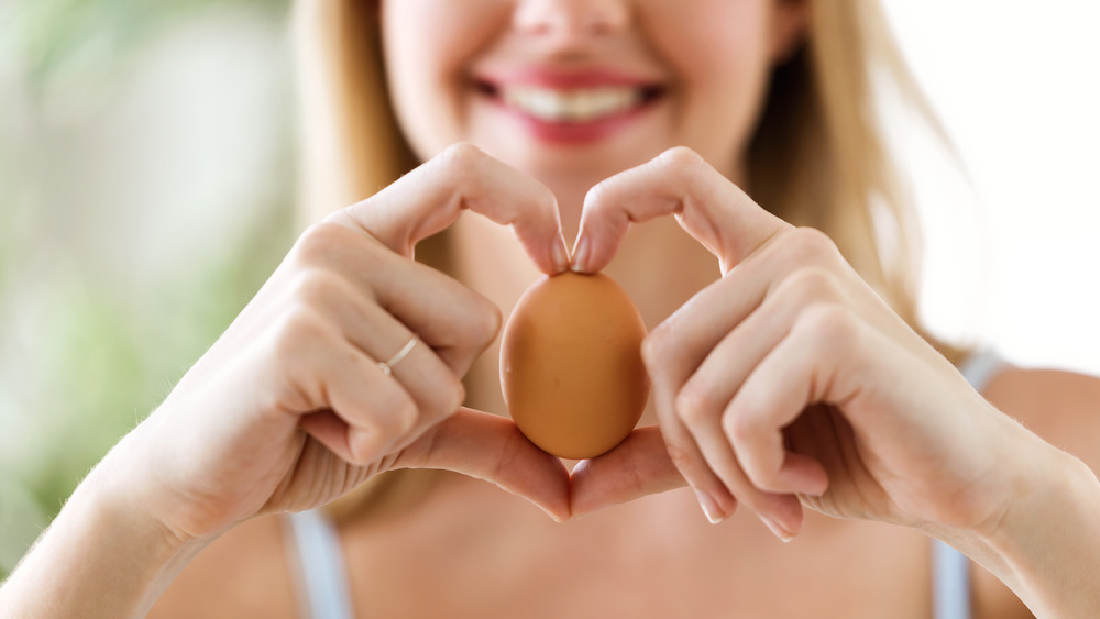 Woman holding brown egg