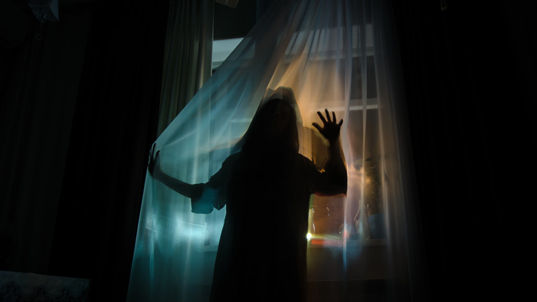 silhouette of woman standing by window