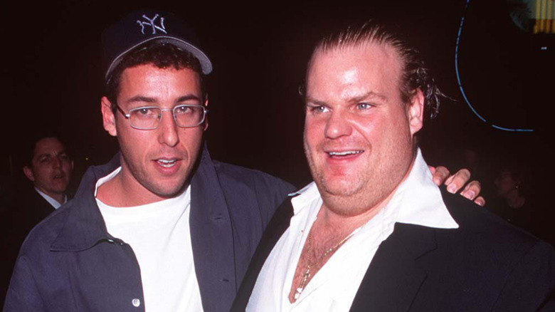 Adam Sandler in glasses with arm around Chris Farley