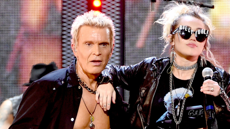 miley cyrus rests arm on billy idol on stage