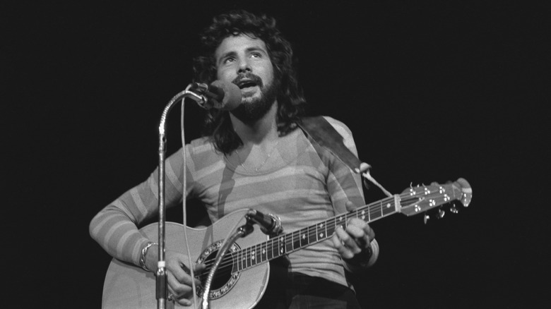 Cat Stevens performing onstage with acoustic guitar