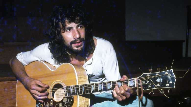 Cat Stevens sat playing guitar