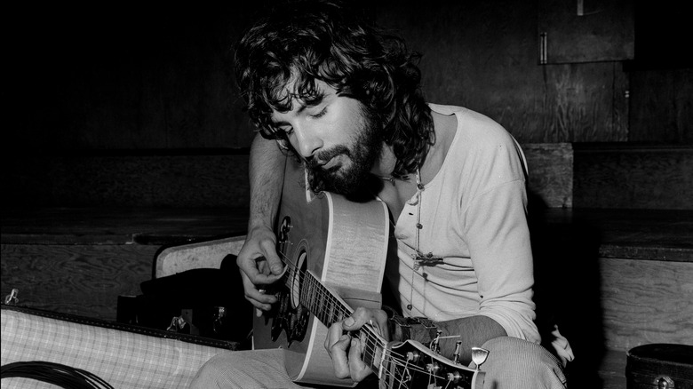 Cat Stevens sat playing acoustic guitar