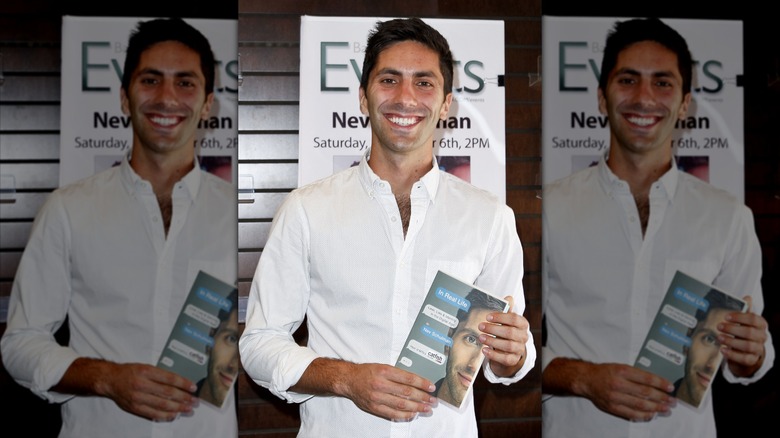 Nev Schulman posing with a copy of his book