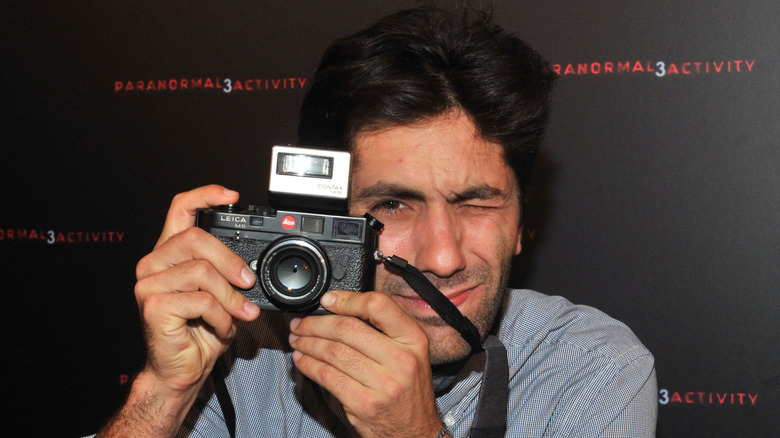 Nev Schulman taking a photo with a camera