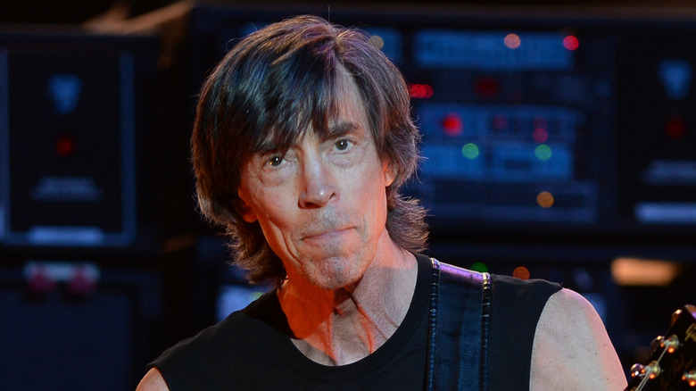 tom scholz plays guitar in front of a bunch of electrical equipment
