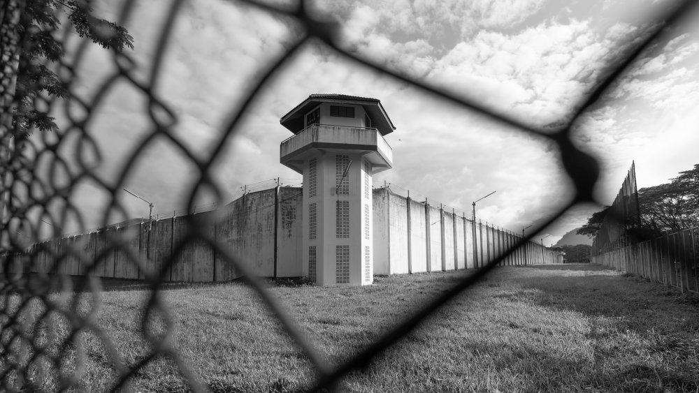 Prison watchtower protected by wire of prison fence.