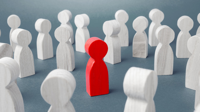 Red wooden figure in crowd 