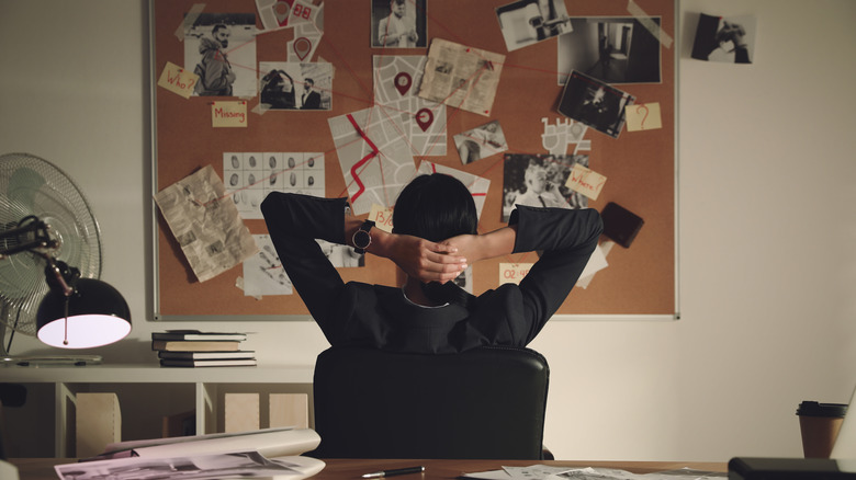 person faces detective bulletin board 