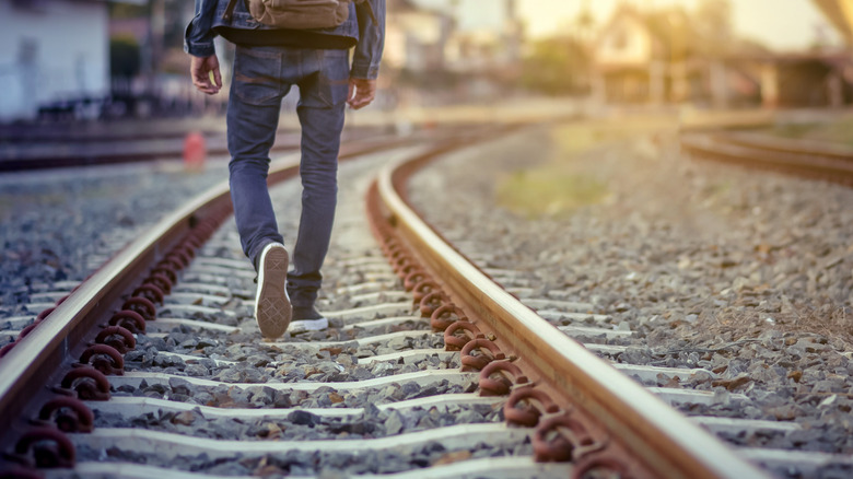 man walking on railroad