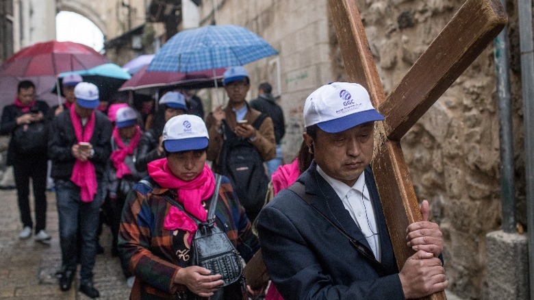 Pilgrims walking with wooden crosses