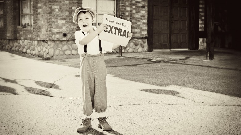boy in cap with newspaper