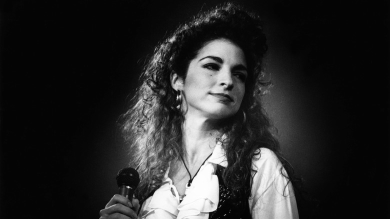 Gloria Estefan onstage with microphone in 1990