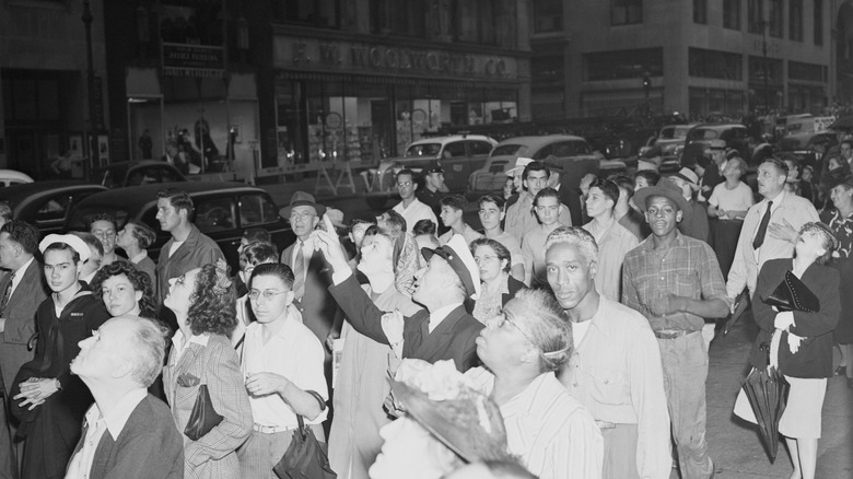New Yorkers staring and pointing up after a plane crashed into the Empire State Building