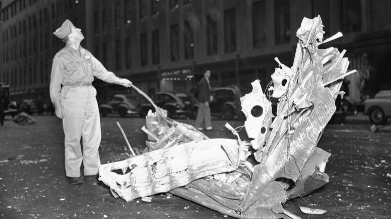 A soldier with part of the plane debris that fell into the street