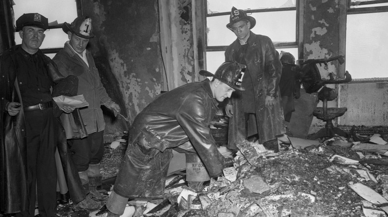 Firefighters sift through crash site debris in the Empire State Building