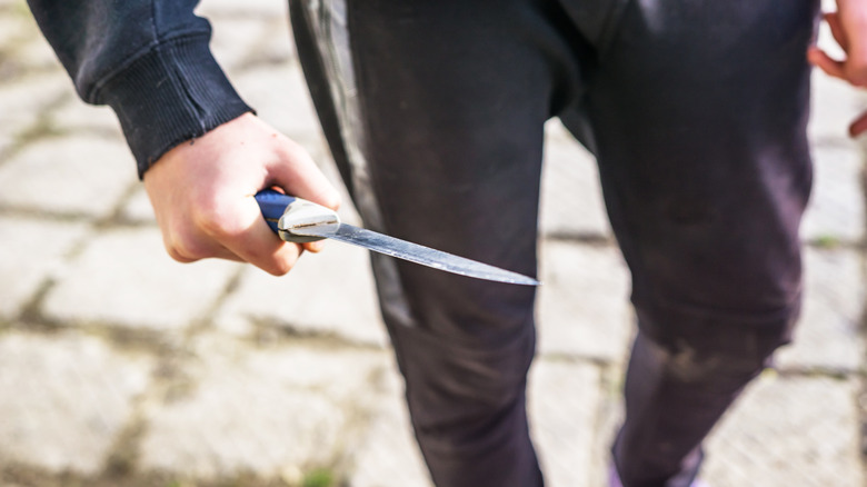 white teen boy holding a knife