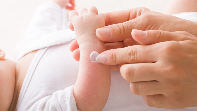 Adult hands caring for infant in medical setting
