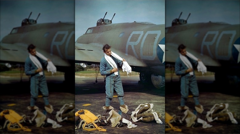 Staff Sergeant Frank T. Lusic putting on protective clothing and flight gear in front of a B-17, 1943