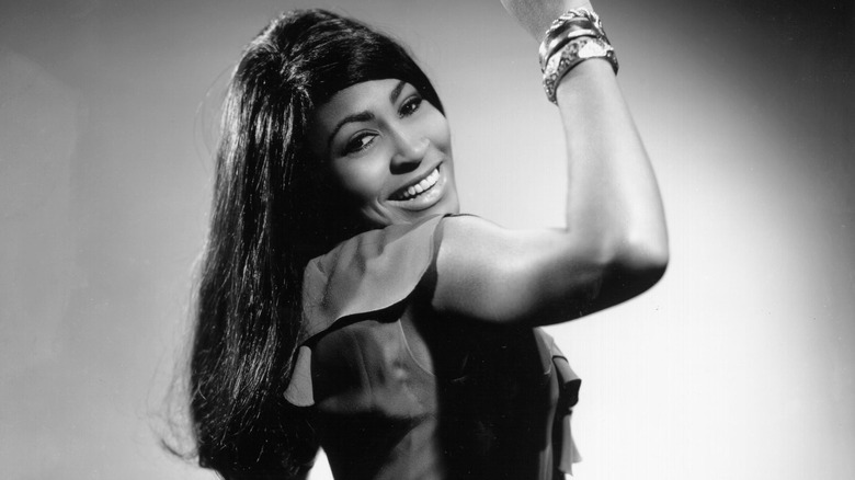 Tina Turner arm up smiling