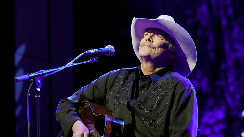Alan Jackson performing on stage in black shirt