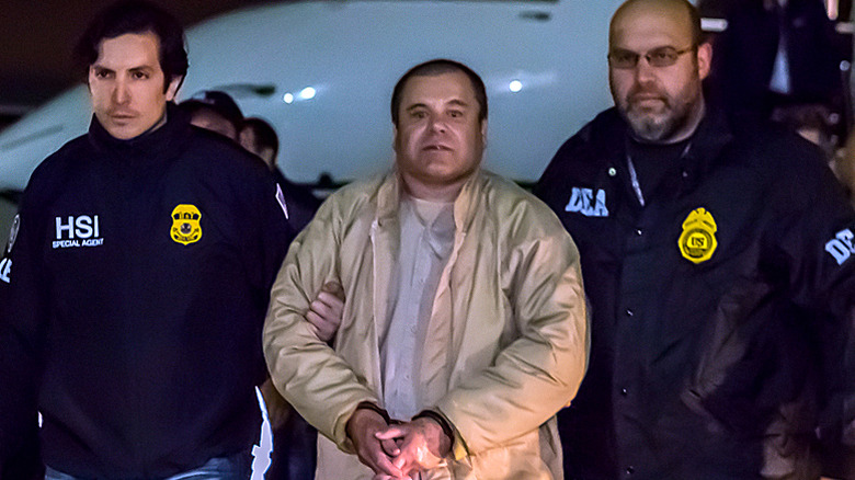 El Chapo held and flanked by two U.S. agents