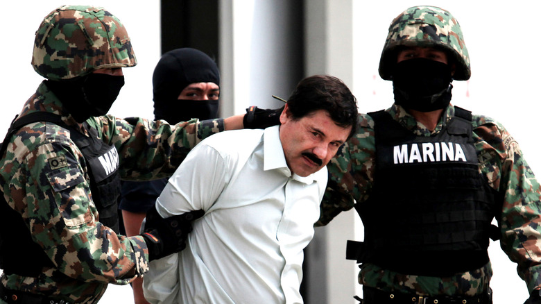 El Chapo held and flanked by two soldiers