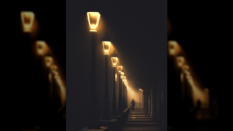 Streetlights at night with lone figure