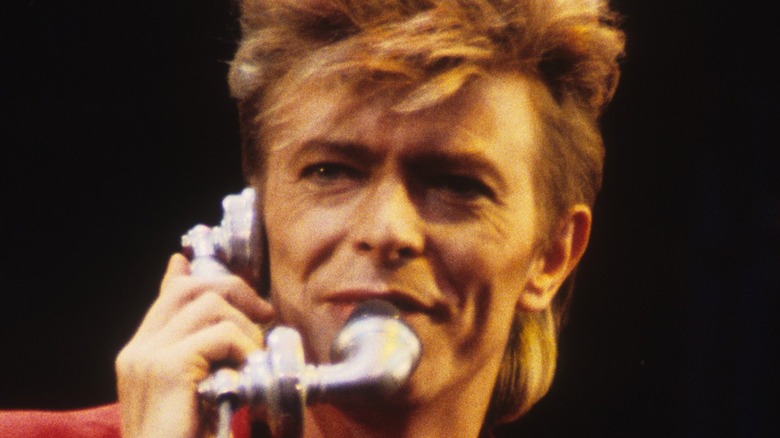 David Bowie singing into a telephone