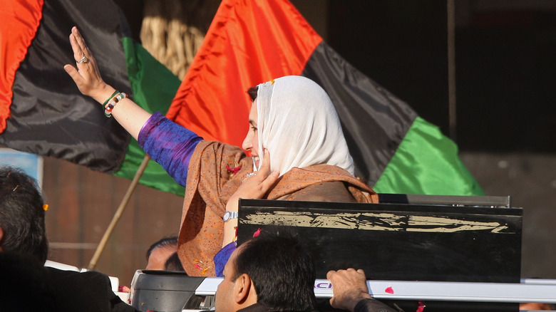 Benazir Bhutto waving from a car