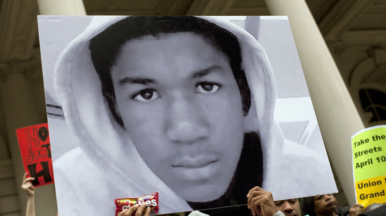 Protestors carry signs with Martin's face