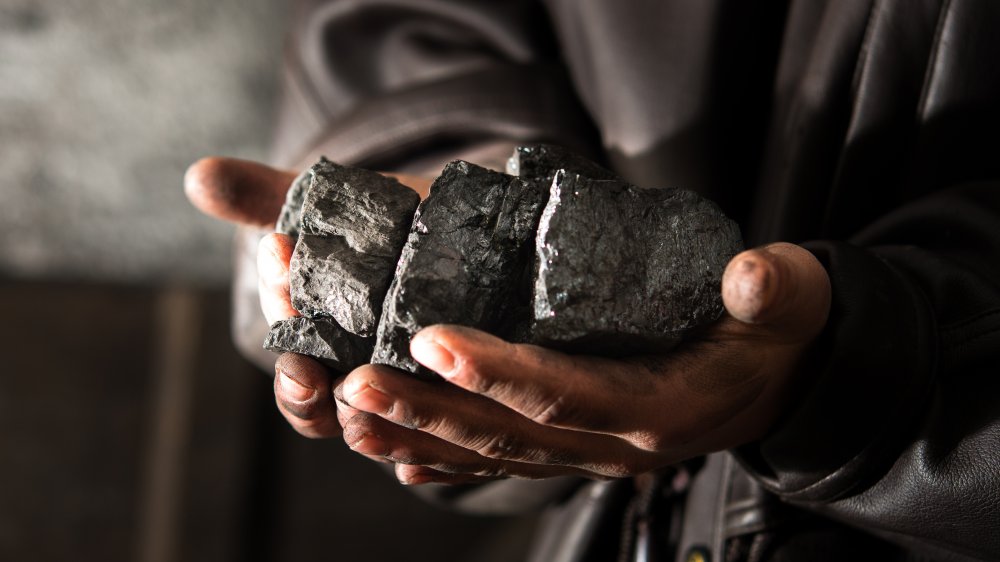 dirty hands holding coals