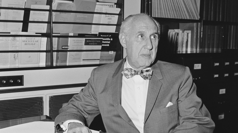Dr Alan Frank Guttmacher sitting at desk