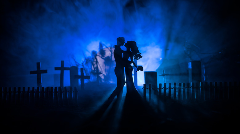 A silhouette of a couple in a graveyard