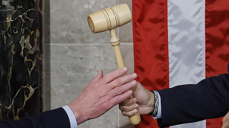 Wooden gavel passed between hands U.S. flag