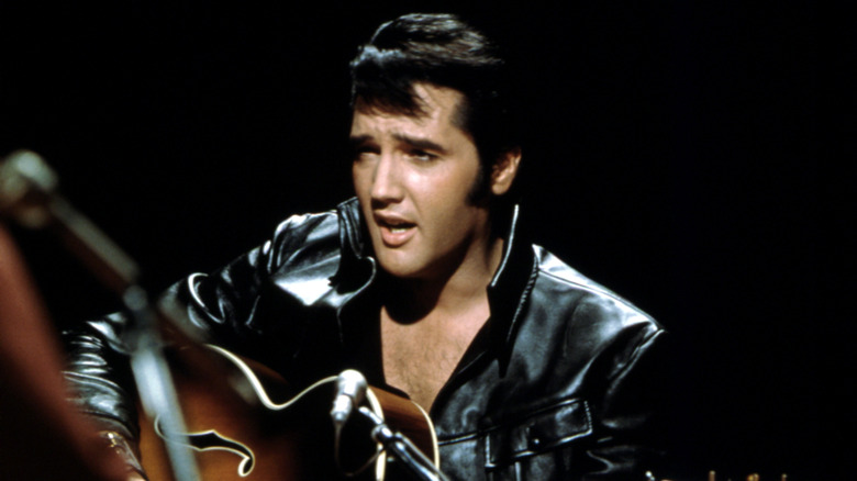Elvis Presley black suit playing guitar