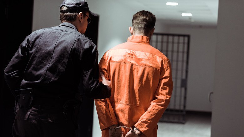officer leading prisoner to cell