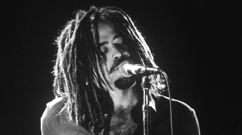 Adam Duritz onstage with microphone and dreadlocks