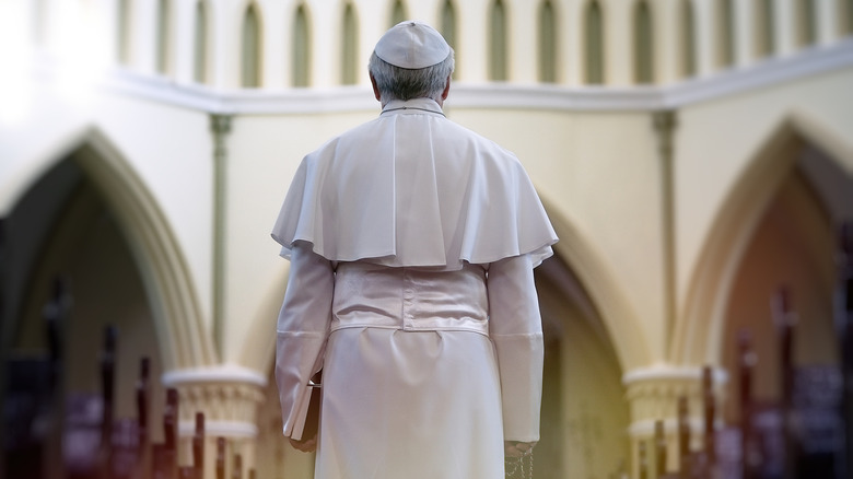 Pope holding a Bible in church