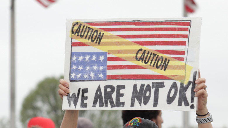 Protestor holding upside down American flag