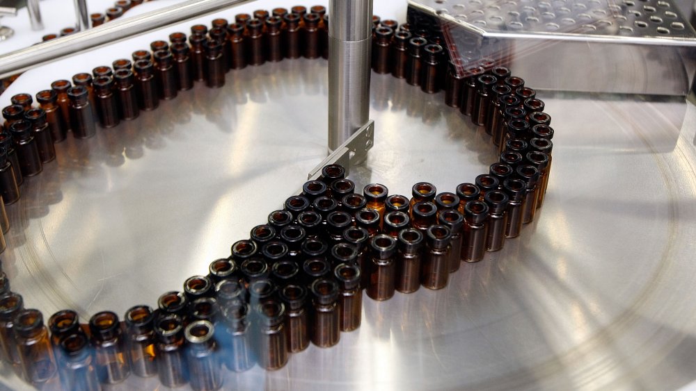 Small glass vial like those that will hold tuberculosis vaccines move through a filling machine during a tour of the Aeras Global TB Vaccine Foundations' new manufacturing plant May 4, 2009