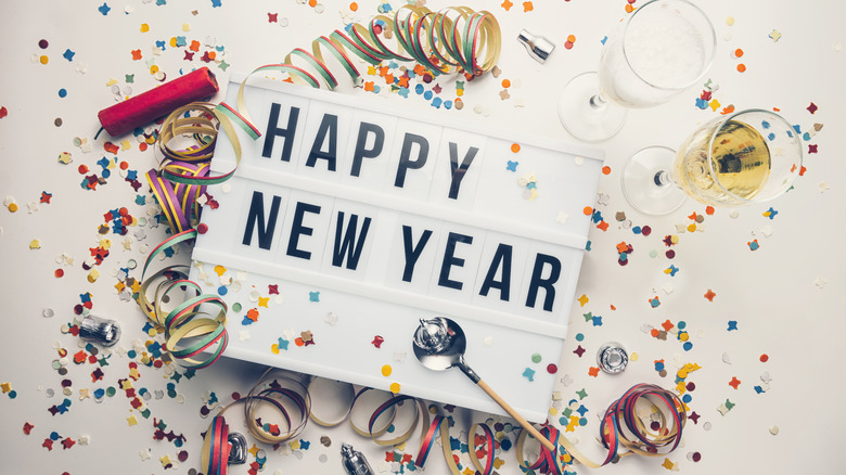 Sign reading "Happy New Year" and party favors on table