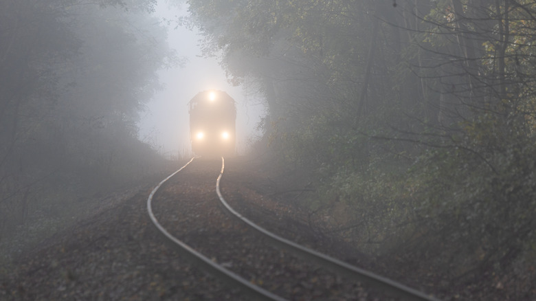 A train drives through fog