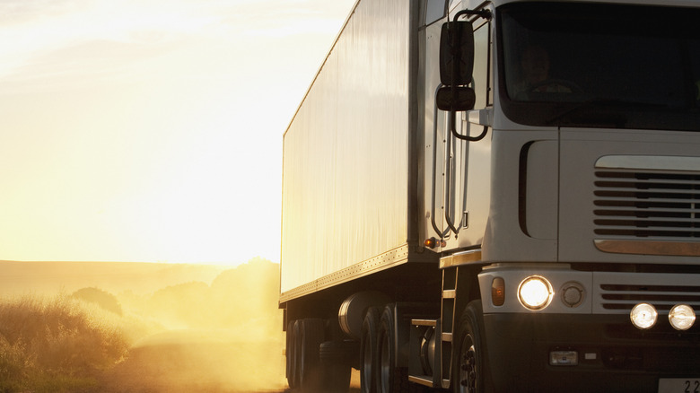 A truck dives away from a sunset