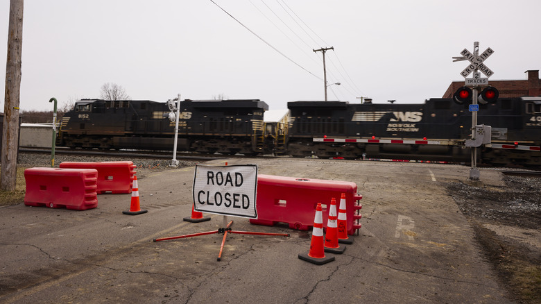Traffic control signs warn people away from a Norfolk Southern train